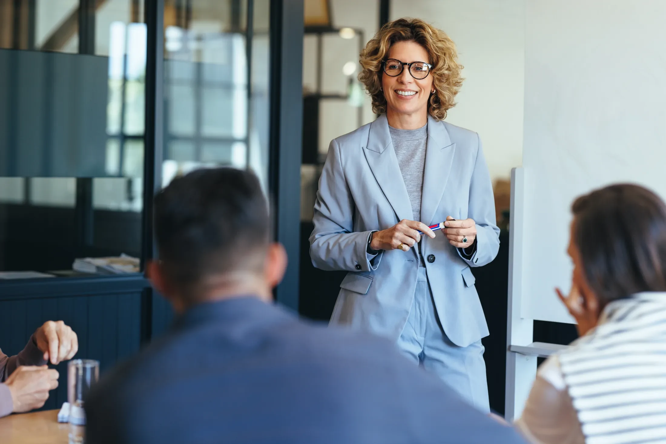 A business leader presenting to colleagues in a meeting.
